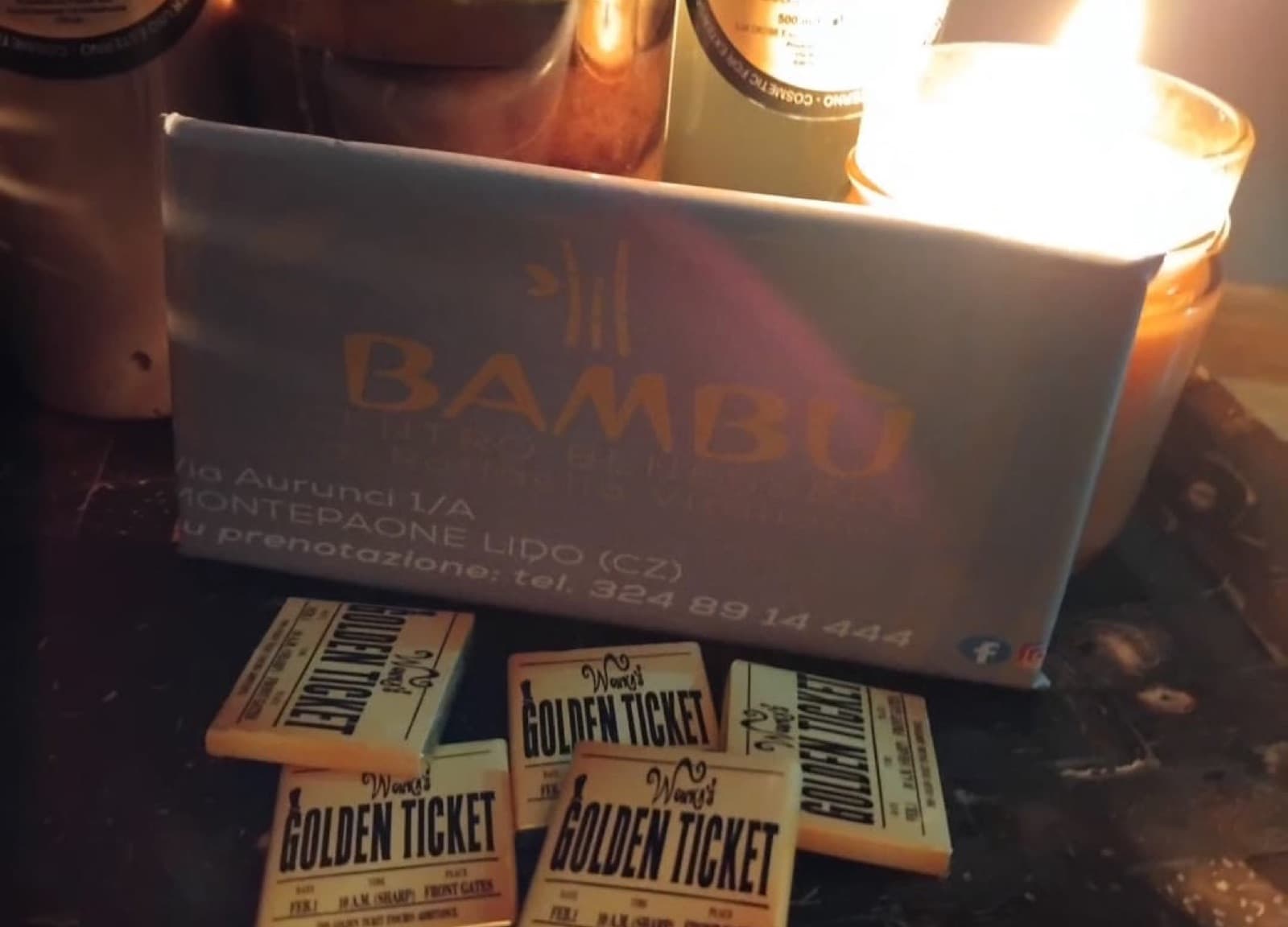 Cofanetto regalo BAMBÙ e biglietti golden ticket alla luce di una candela